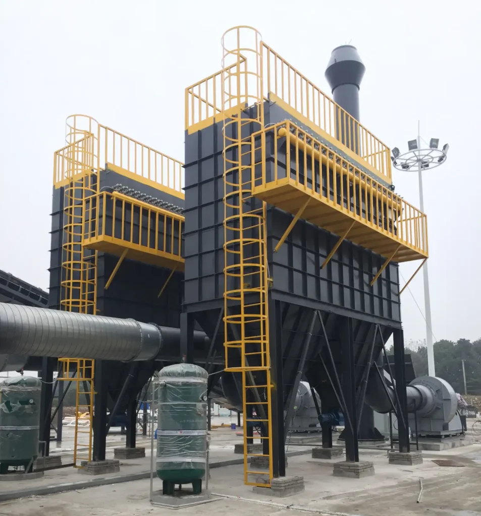 Industrial baghouse dust collector system with ducting and fan installed in factory