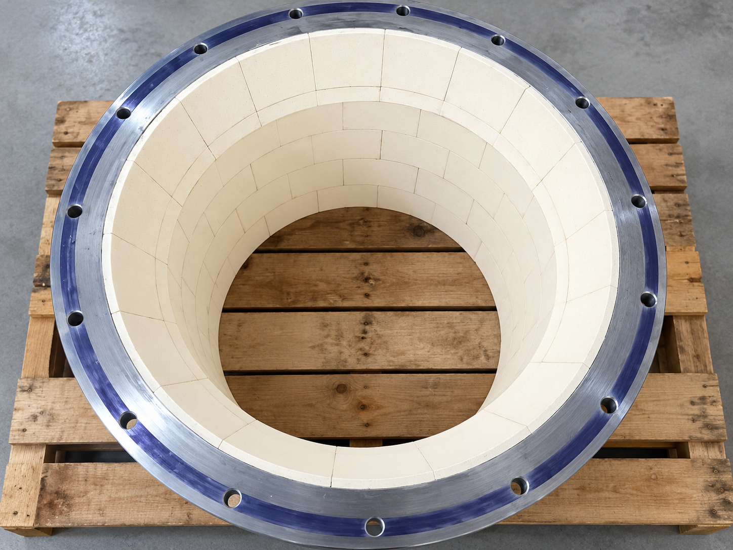White ceramic lining inside a flanged industrial pipe section used as a wear protection detail reference