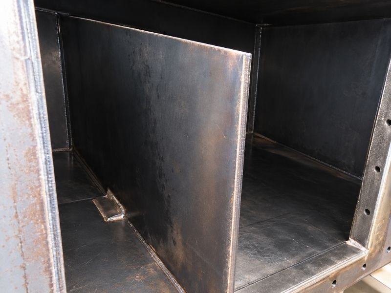 Internal steel baffle inside a baghouse dust collector for redirecting abrasive airflow